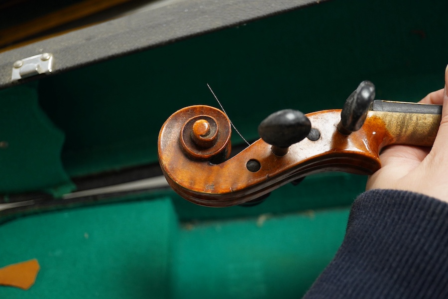 Four cased violins; an early 20th century violin, body 36cm, fitted with a microphone pick up taking a quarter inch jack plug, an early 20th century half size violin, body 32cm, and two student violins. Condition - poor